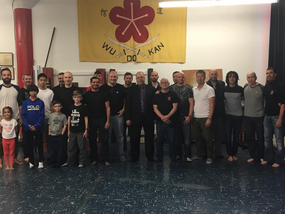 Wudokan Students and Instructors in Front of School Crest